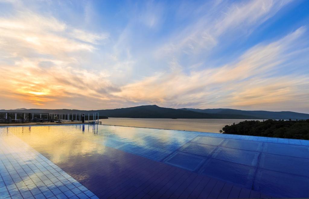 a swimming pool with a view of the water at New Akan Hotel in Akankohan