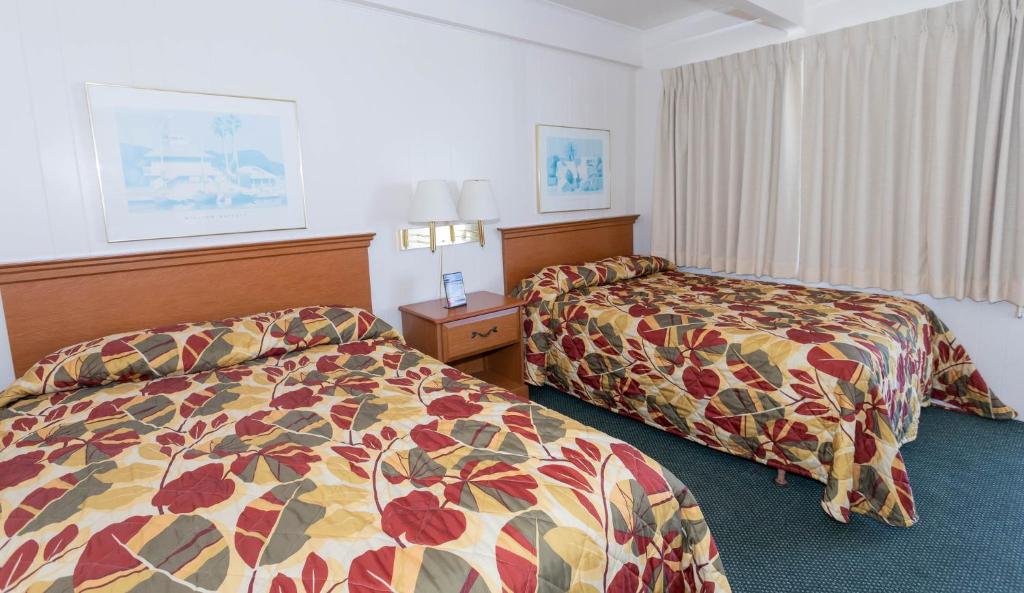 ein Hotelzimmer mit zwei Betten in einem Zimmer in der Unterkunft Fish Tales Boardwalk Inn &amp; Ocean Mecca Motel in Ocean City