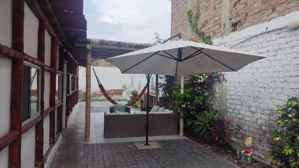 an umbrella sitting on a patio next to a building at Casa rustica en Pulpos in Lima