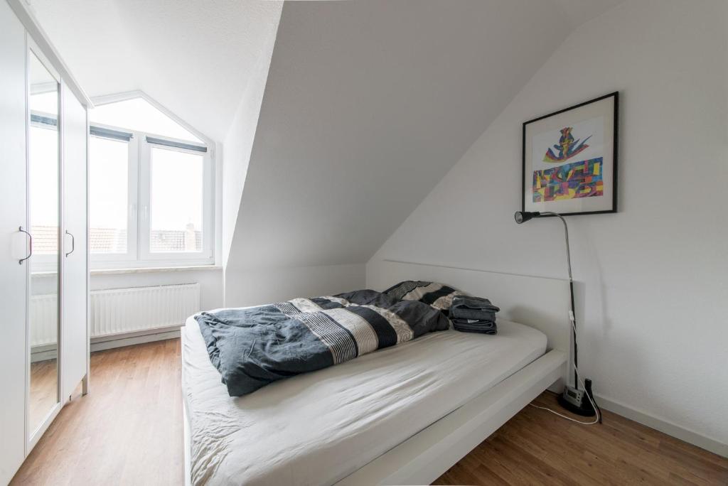 um quarto branco com um sofá com um cobertor em Private Rooms em Hanôver