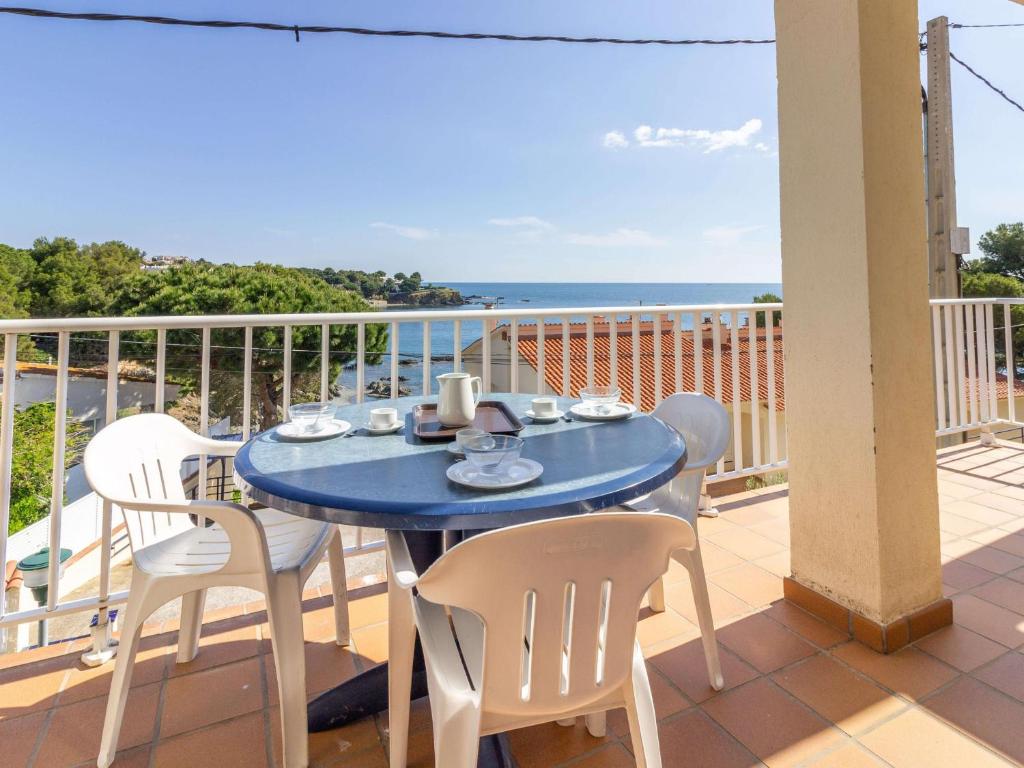 een blauwe tafel en stoelen op een balkon met uitzicht op de oceaan bij Apartamento Llançà, 2 dormitorios, 6 personas - ES-228-14 in Llança