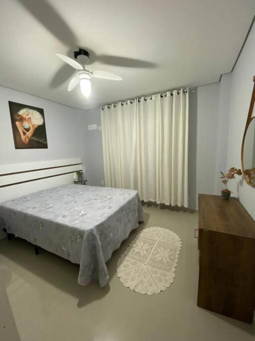 a bedroom with a bed and a ceiling fan at Apartamento in Navegantes