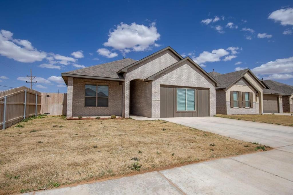 a large house with a fence in a yard at Entire House~ Spacious~ Prime Location~ Backyard in Lubbock