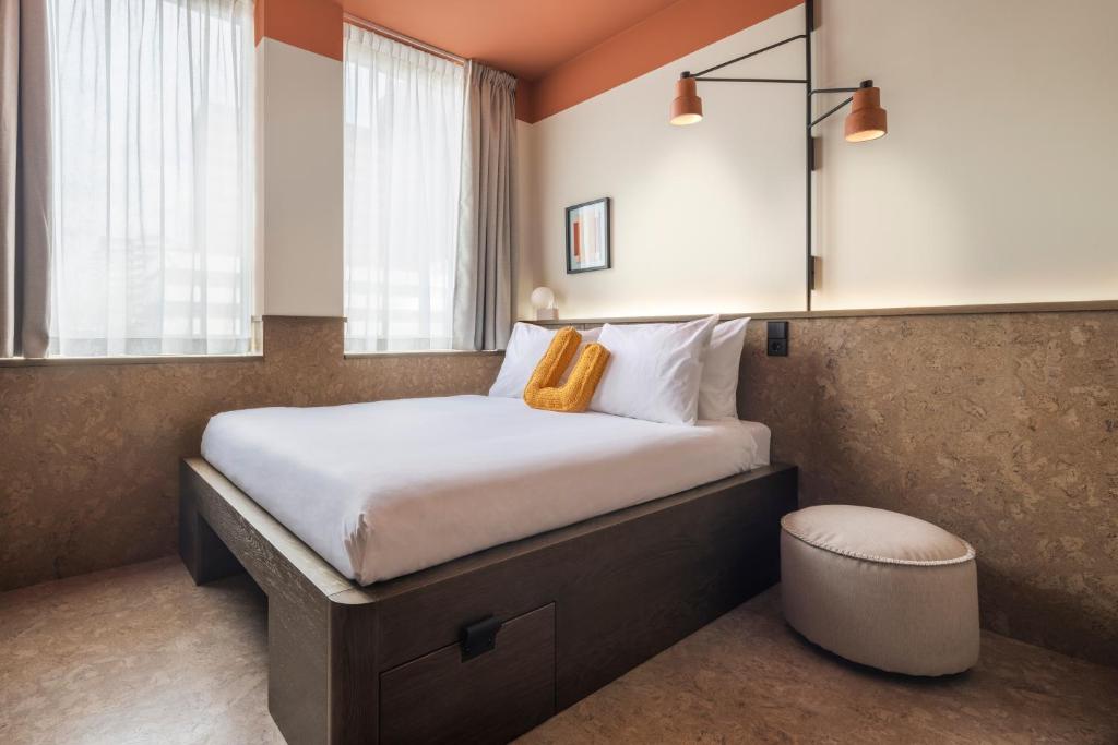 um quarto com uma cama grande e uma janela em The Usual Rotterdam em Roterdã