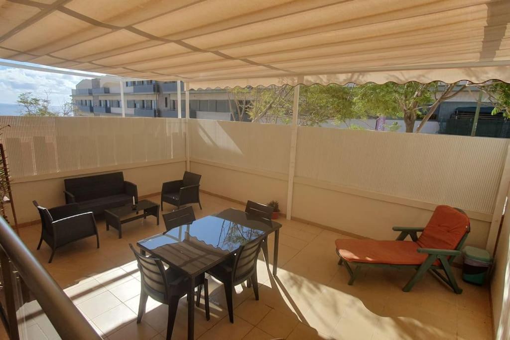 a patio with a table and chairs on a balcony at Apartamento con amplia terraza en Candelaria in Candelaria