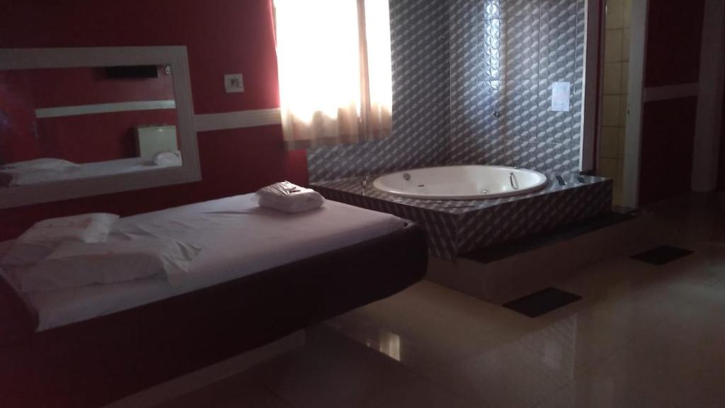 a bathroom with a tub and a sink and a bath tub at Hotel 1001 noites in Brasília