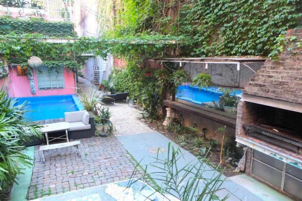 ブエノスアイレスにあるCasa San Telmo 12のソファとピアノ付きの庭園