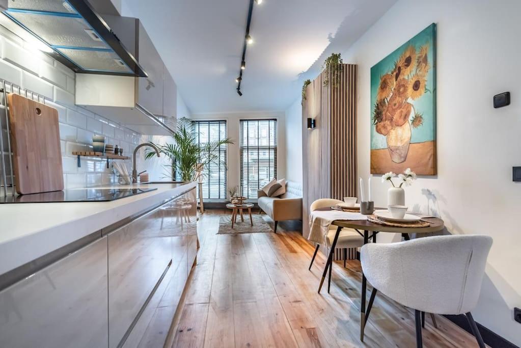 eine Küche mit einer Theke und einem Tisch mit Stühlen in der Unterkunft CanalView Luxury Apartment in Amsterdam