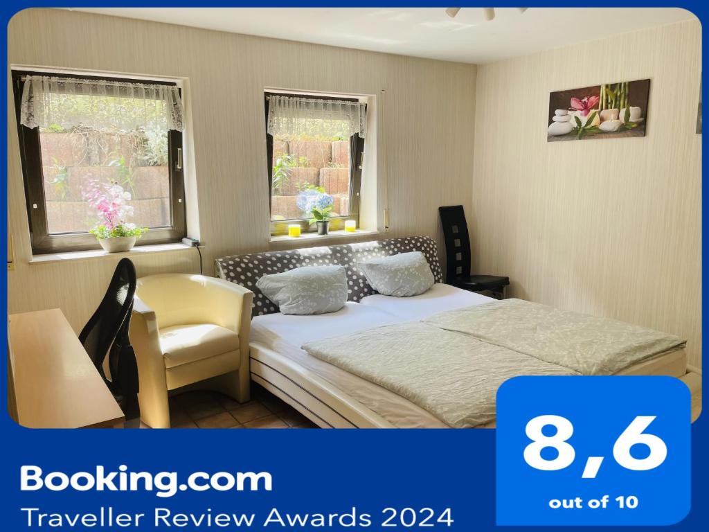 ein Schlafzimmer mit einem Bett und einem Stuhl sowie zwei Fenstern in der Unterkunft Privatunterkunft mit Bad und Küche in Seenähe in Zülpich