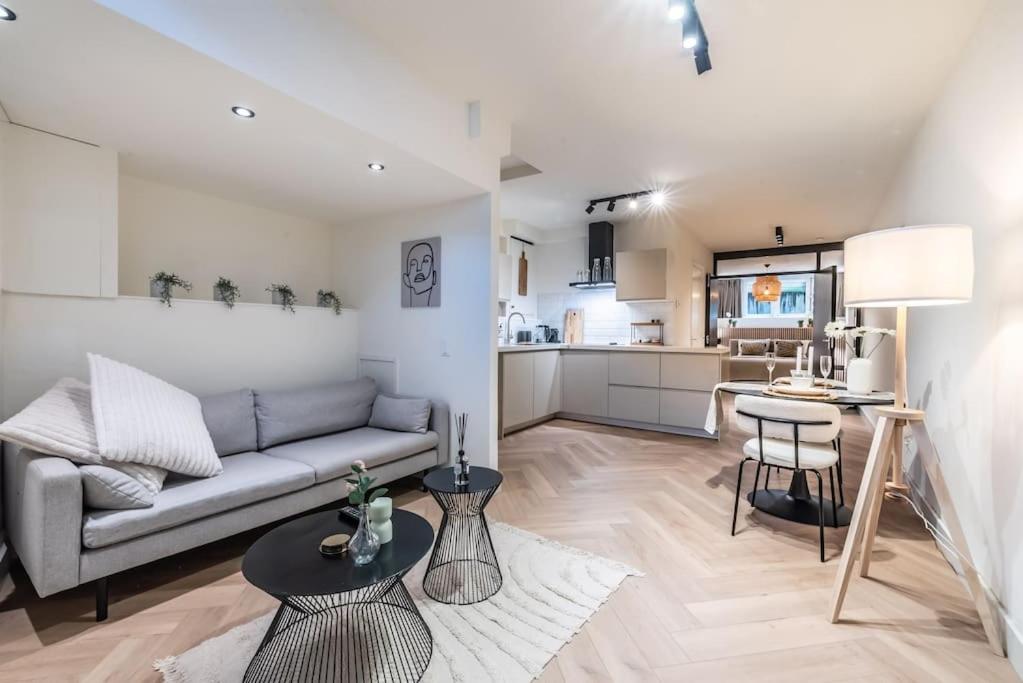 ein Wohnzimmer mit einem Sofa und einer Küche in der Unterkunft Central Luxury Apartment in Amsterdam