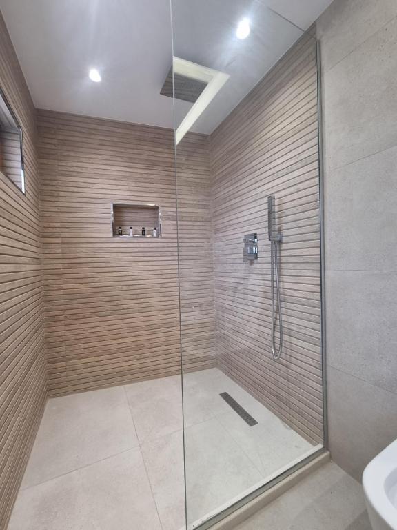een badkamer met een douche met een glazen deur bij HOTEL VILA TWIX in Berat