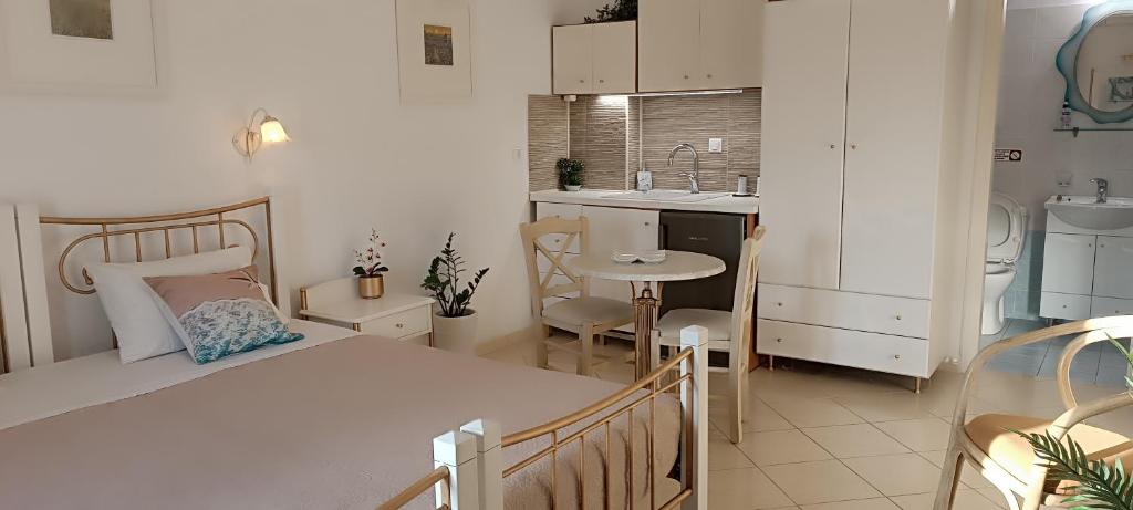 una piccola cucina con un letto e un tavolo in una stanza di Actis studios 1 a Stelida