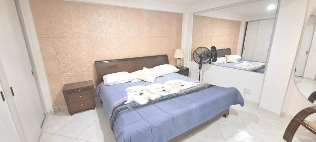 Un dormitorio con una cama con dos perros. en Amplio y lindo apartamento, en Medellín