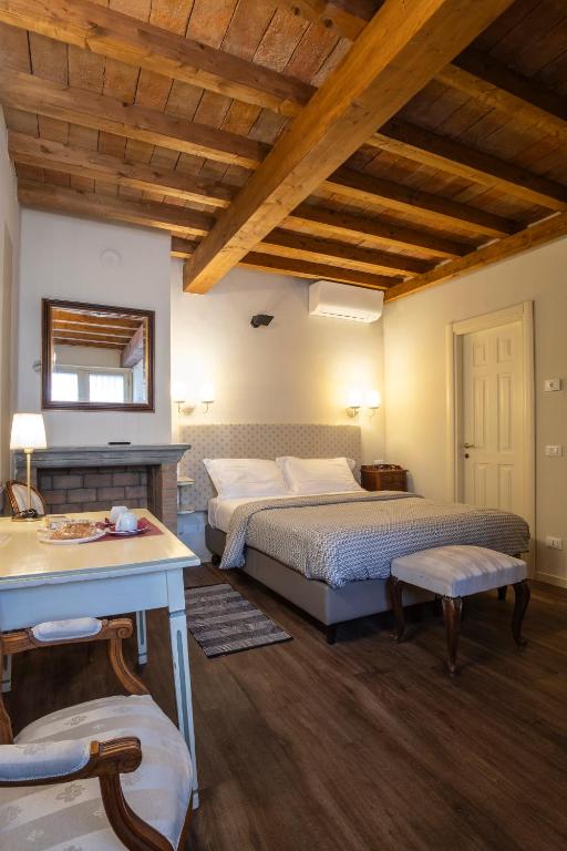 een grote slaapkamer met 2 bedden en een tafel bij Il Cortiletto in Piacenza