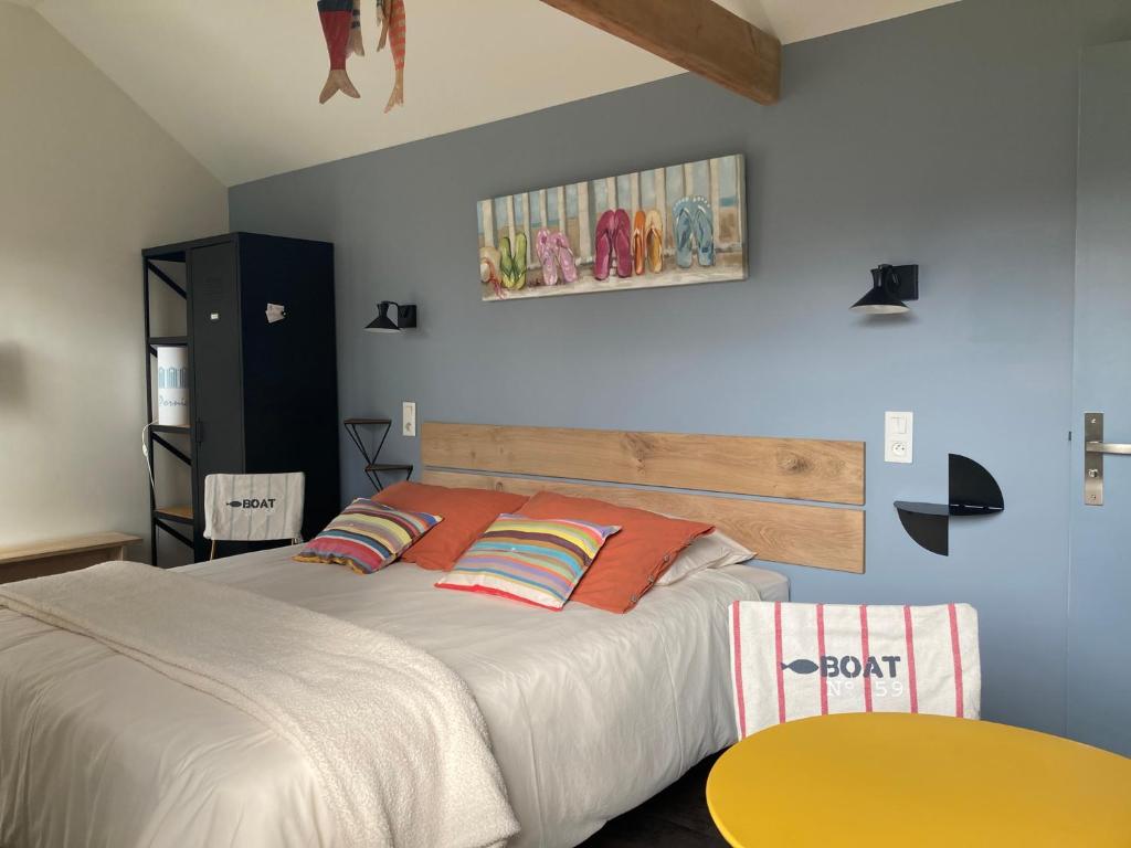 1 dormitorio con 1 cama grande con almohadas de color naranja en A La Birochère Chambre d hôtes classée 3 clés et Accueil Vélo en Pornic