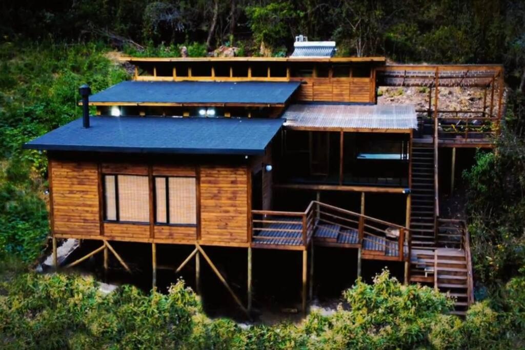 Cabaña de madera con techo azul en una colina en Chalet el Majuy, en Cota