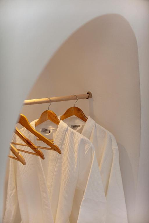 a pair of white shirts hanging on a rack at Kapari Suites Santorini in Fira