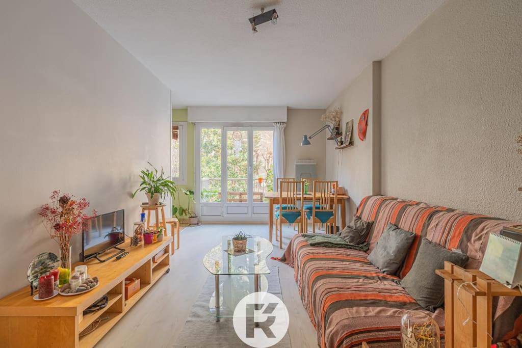 un salon avec un canapé et une table dans l'établissement R'Apparts T2 Le Jardin Charmant, à Grenoble