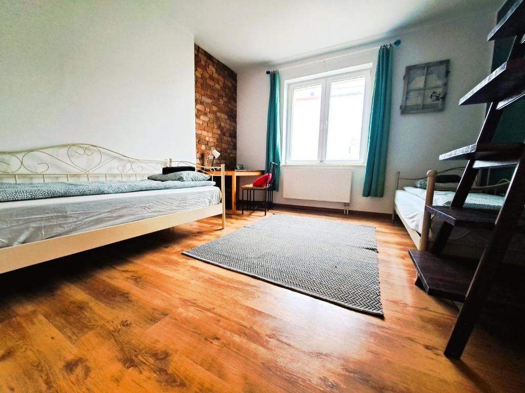 a bedroom with a bed and a table and a window at Apartament z ogrodem w sercu Torunia in Toruń