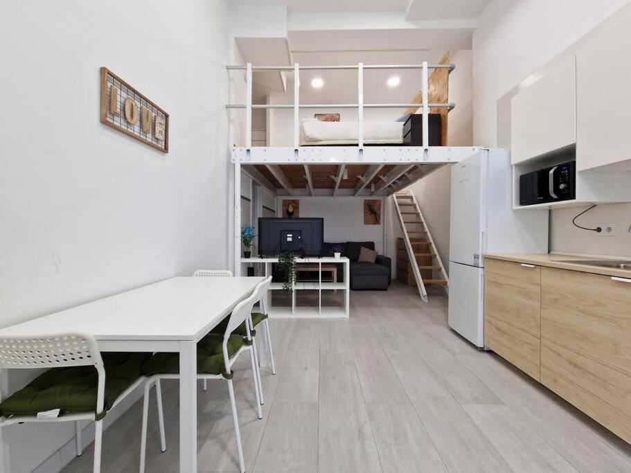 a kitchen and living room with a loft bed at Loft Seco super equipado cerca de metro Pacífico in Madrid