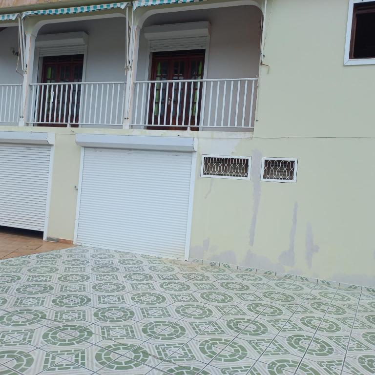 um edifício com duas portas de garagem e um piso de azulejo em Villa bella em Sainte-Anne
