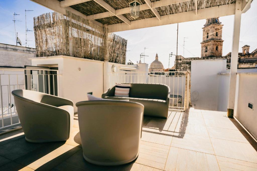 a balcony with couches and chairs on a building at Le Contrade Chiasso Cafaro in Monopoli