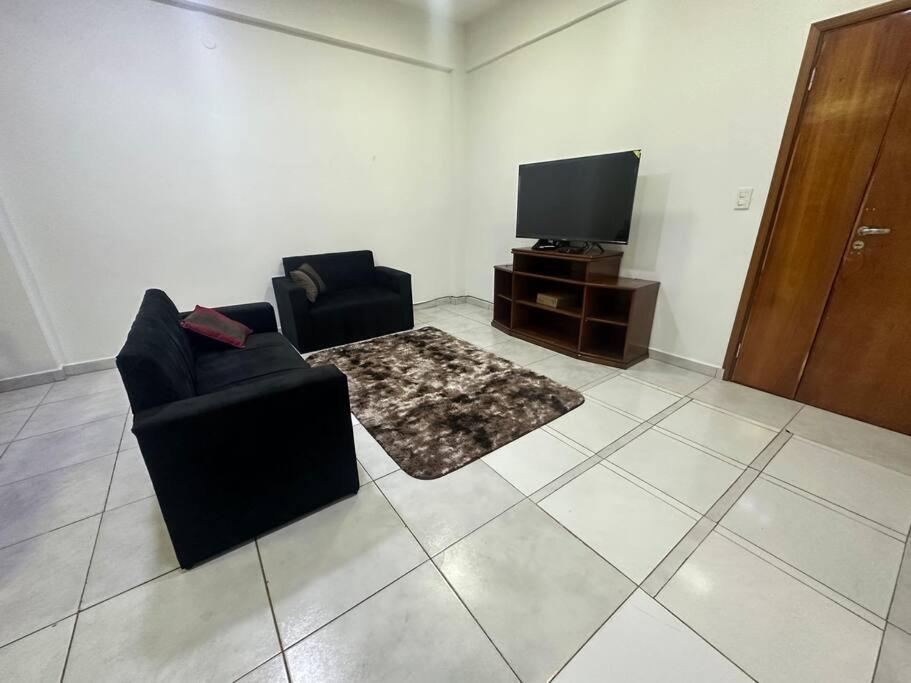 un soggiorno con 2 sedie e una TV di Departamento Circuito Comercial a Encarnación