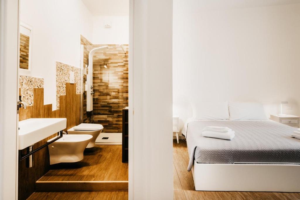 1 dormitorio con 1 cama y baño con lavamanos en Le Contrade Vico Alba, en Monopoli