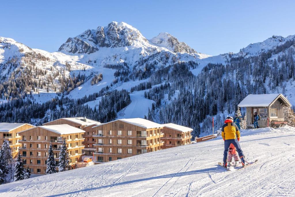 eine Person auf Skiern im Schnee vor einem Hotel in der Unterkunft "Home to Enjoy" Premium Appartement in Sonnenalpe Nassfeld