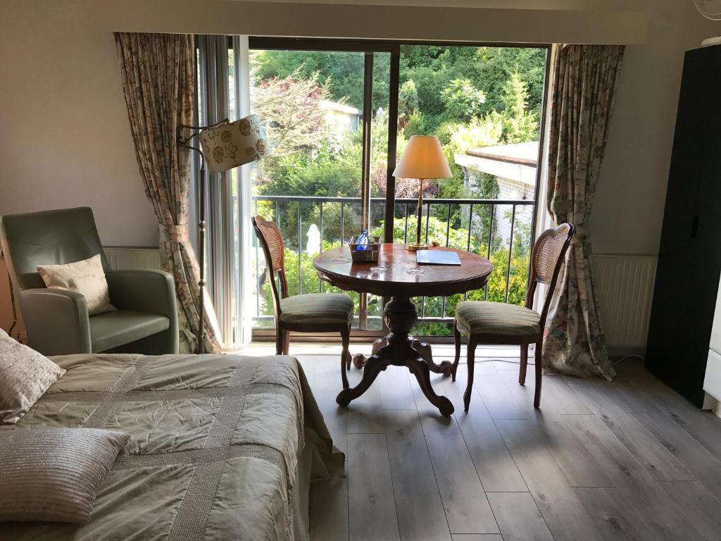 a bedroom with a table and chairs and a balcony at Villa 't Haasduin in Wijk aan Zee