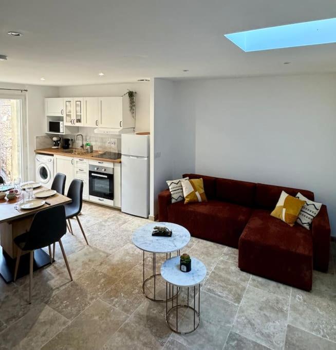 Il comprend un salon avec un canapé et des tables ainsi qu'une cuisine. dans l'établissement Appartement lumineux avec terrasses, au Luc