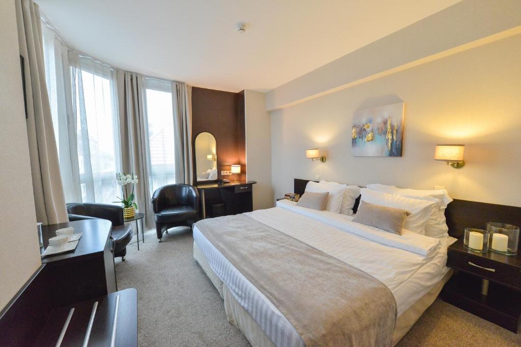 a hotel room with a large bed and a desk at Art Plaza Hotel in Sofia