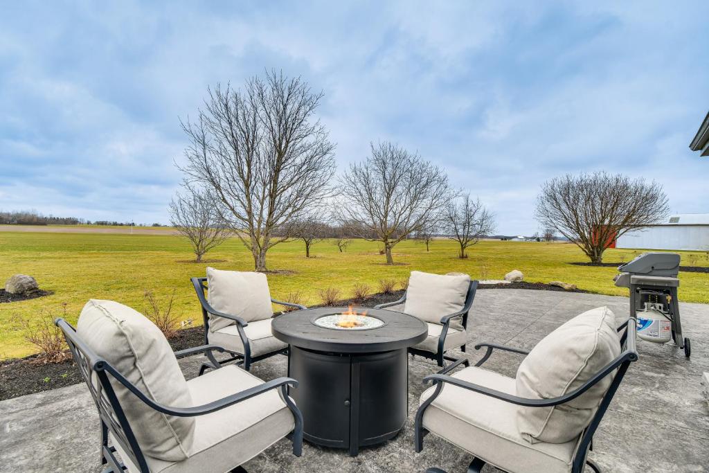 eine Terrasse mit einem Tisch, Stühlen und einem Grill in der Unterkunft Auburn Finger Lakes Farmhouse with Open Views! in Auburn