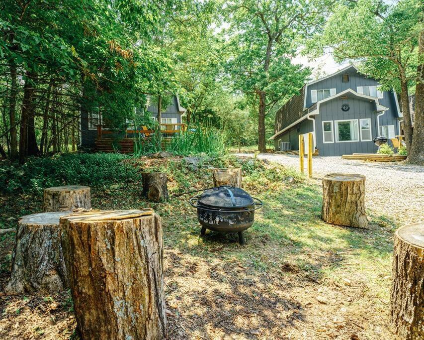 a grill in a yard with trees and a house at Indian Point Villa#5 at Tribesman Resort on Table Rock Lake near Silver Dollar City, Branson in Branson