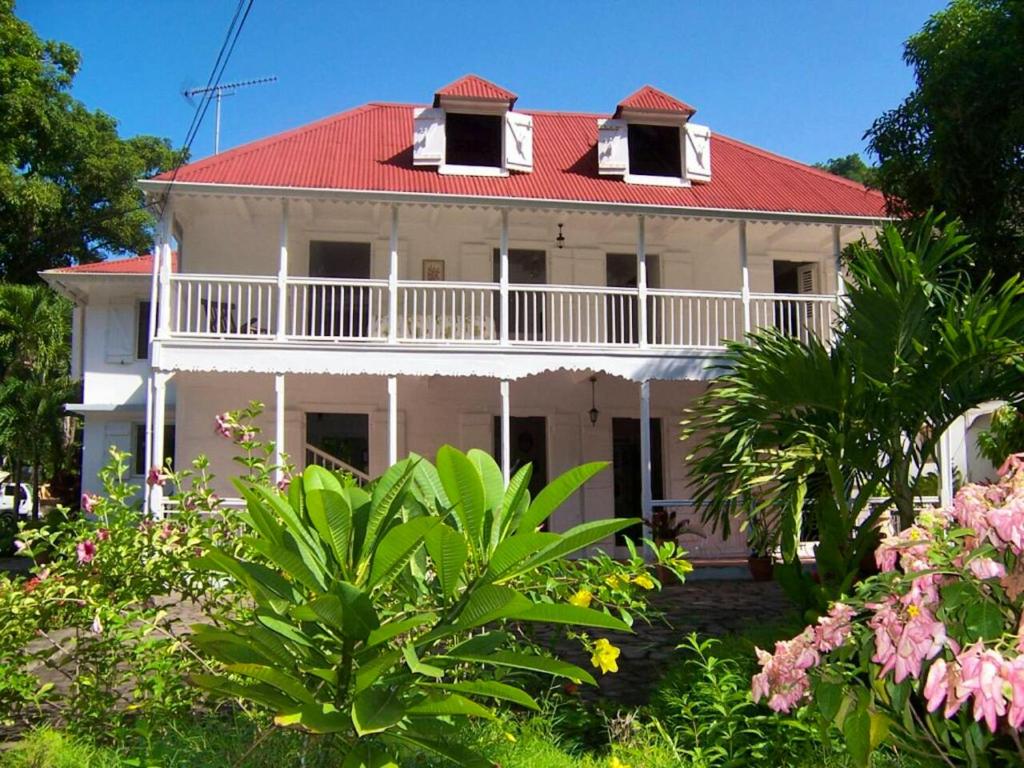 een groot wit huis met een rood dak bij Villa de 6 chambres avec wifi a Vieux Habitants a 3 km de la plage in Vieux-Habitants
