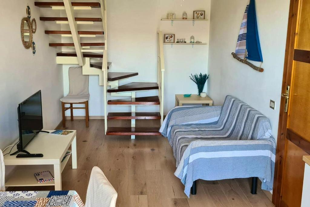 um quarto com 2 camas e uma escada em espiral em 2 bedrooms property at Villasimius 1 km away from the beach em Villasimius