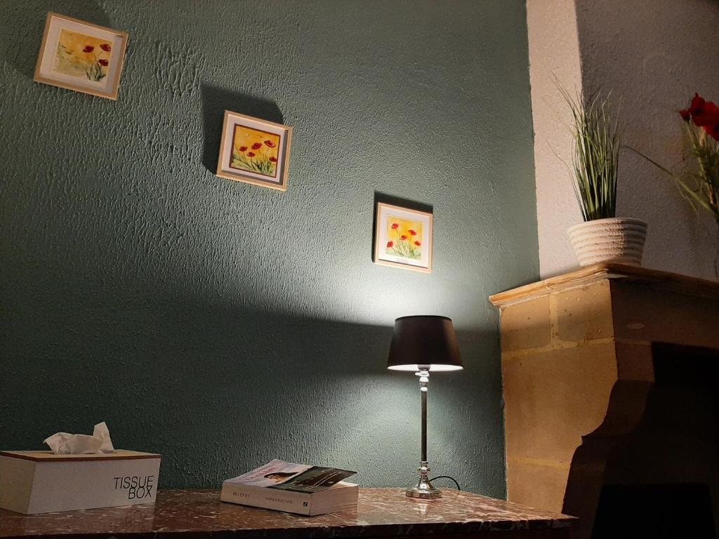 蒙特爾梅的住宿－Chez Many, par Fred et Henri，墙上桌子上的一盏灯