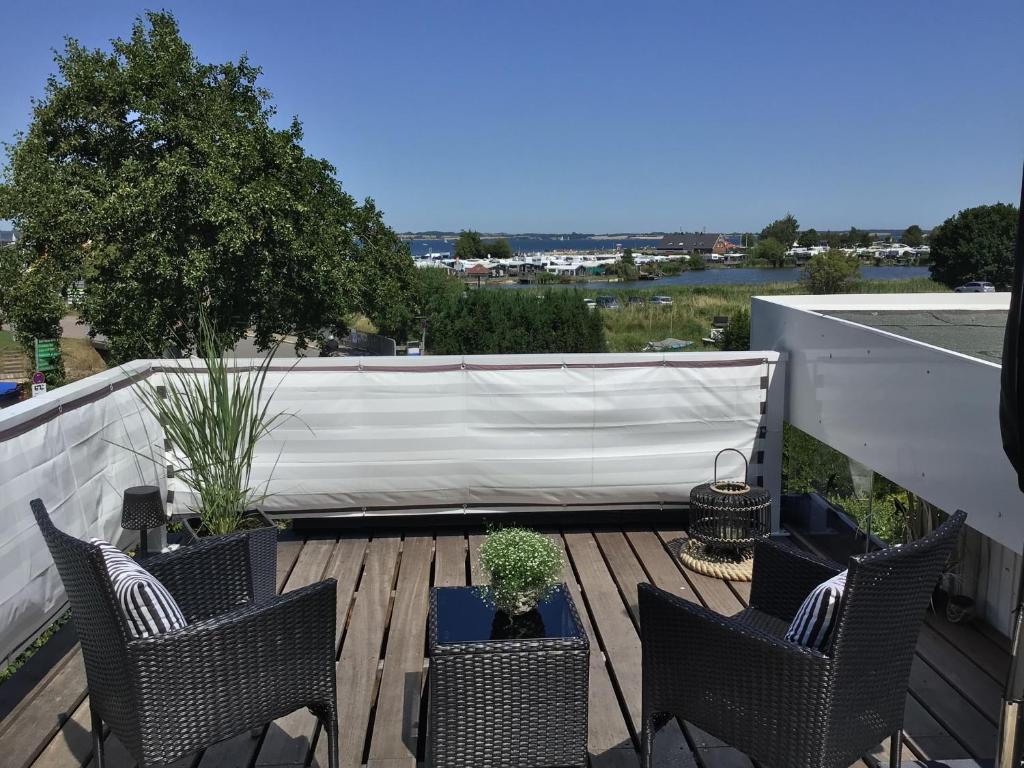 a deck with chairs and plants on a roof at Strandhaus Fördeblick in Langballig
