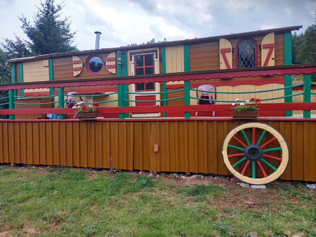 un vagón de tren con una casa encima de una valla en ROULOTTE DU PERE NOEL, en Ban-sur-Meurthe-Clefcy