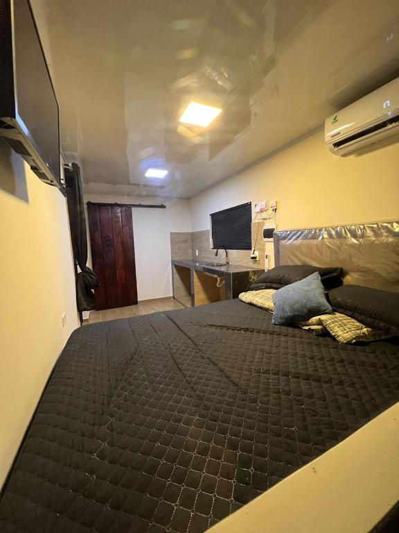 a large bed in a room with a desk at Container Home Py in Puerto Presidente Franco