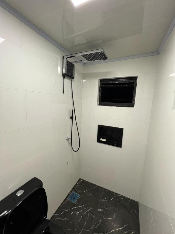 a bathroom with a shower with a toilet and a window at Container Home Py in Puerto Presidente Franco