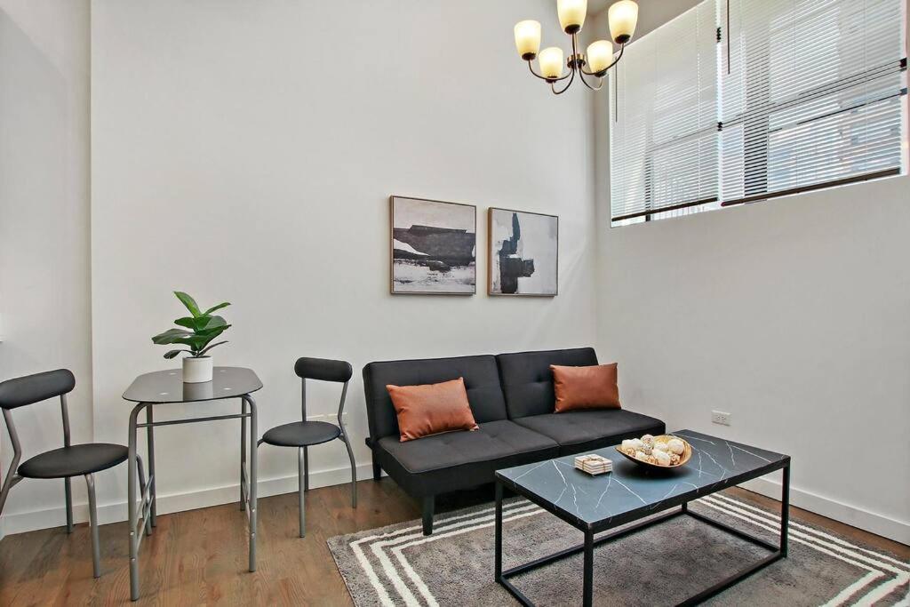 uma sala de estar com um sofá, uma mesa e cadeiras em 1BR Adorable Apt with In-unit Laundry - Lake 206 em Chicago