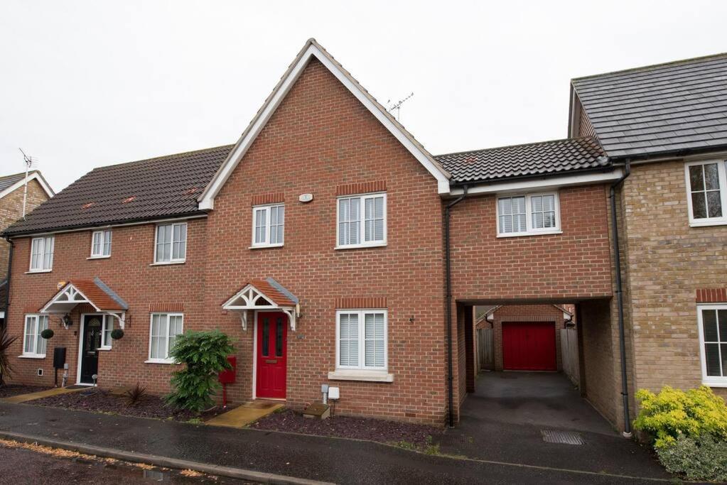 une maison en briques rouges avec une porte rouge dans l'établissement Space Apartments - 3 Bed House Broomfield Chelmsford, à Chelmsford