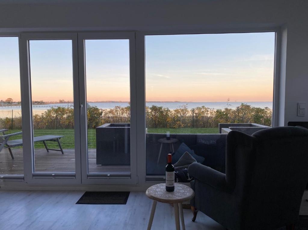 a living room with a couch and a view of the ocean at Bootshaus in Olpenitz