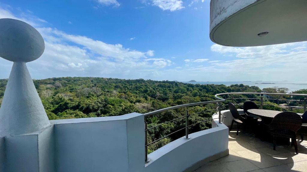 einen Balkon mit einem Tisch und Stühlen sowie Aussicht in der Unterkunft 10G Perfect 2 Bedroom with Ocean and Jungle Views in ArraijÃ¡n