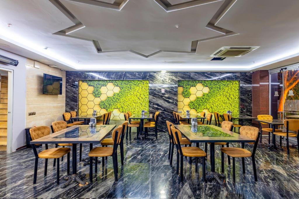 un restaurante con mesas y sillas en una habitación en Dem İstanbul Airport Hotel, en Estambul