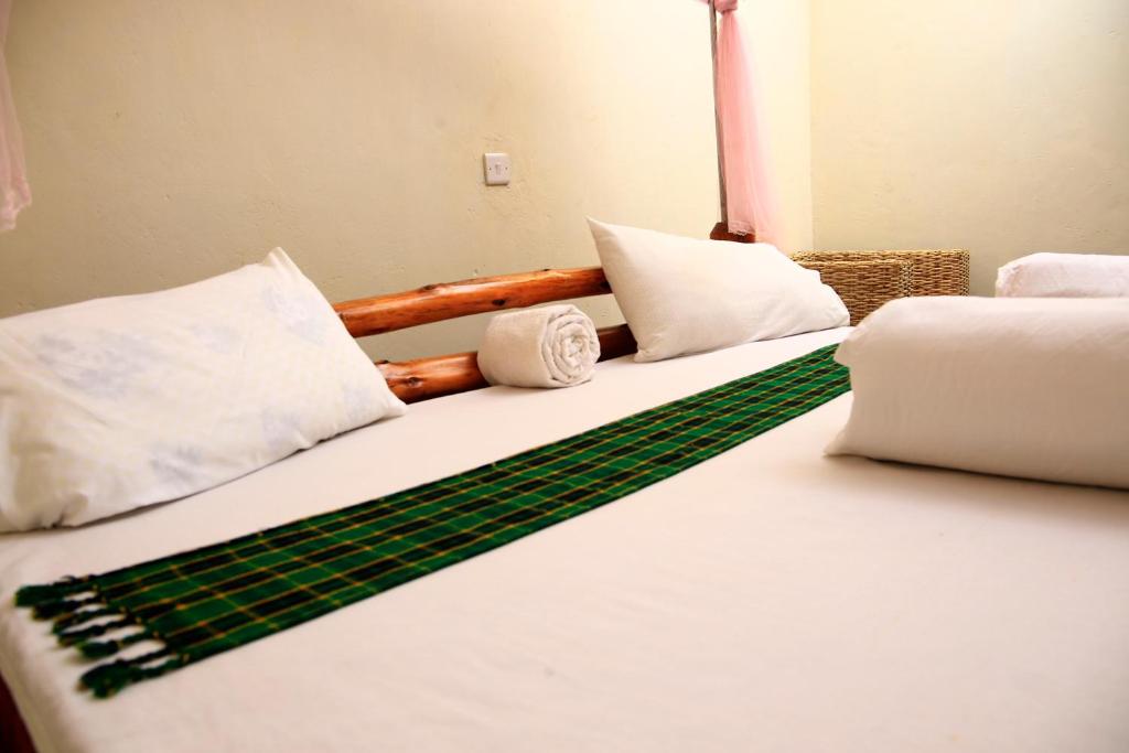 een slaapkamer met 2 bedden met witte en groene lakens bij Sipi Guest House in Kapchorwa