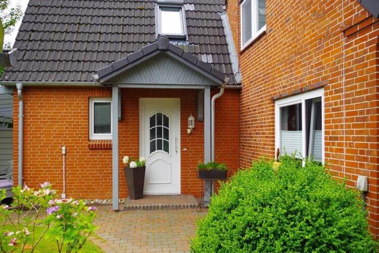 a red brick house with a white door at Semi-detached house Nordseebrise Niebüll - DNS09100i-L in Niebüll