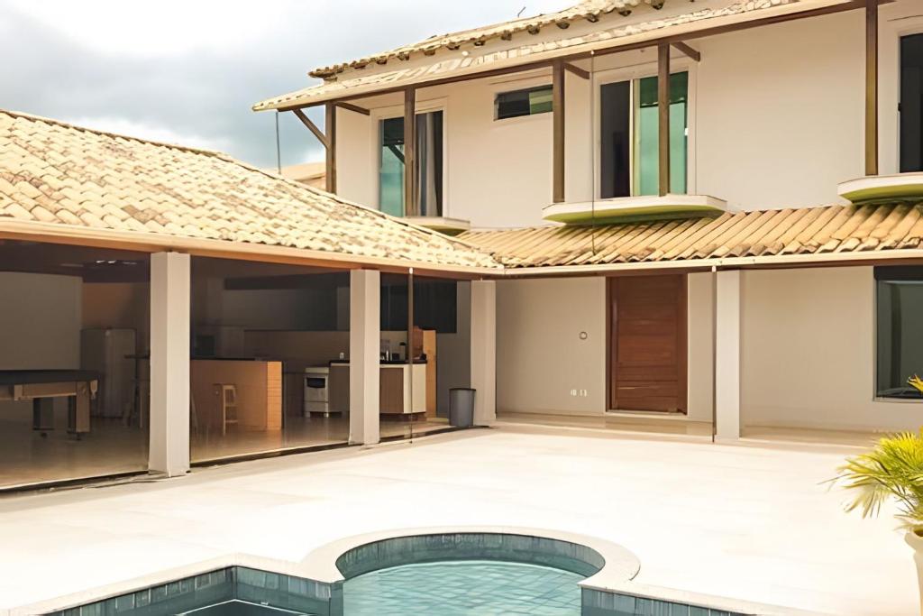 uma imagem de uma casa com piscina em NossoApê Guarua: Piscina | Churrasqueira | Ar-condicionado em Juiz de Fora