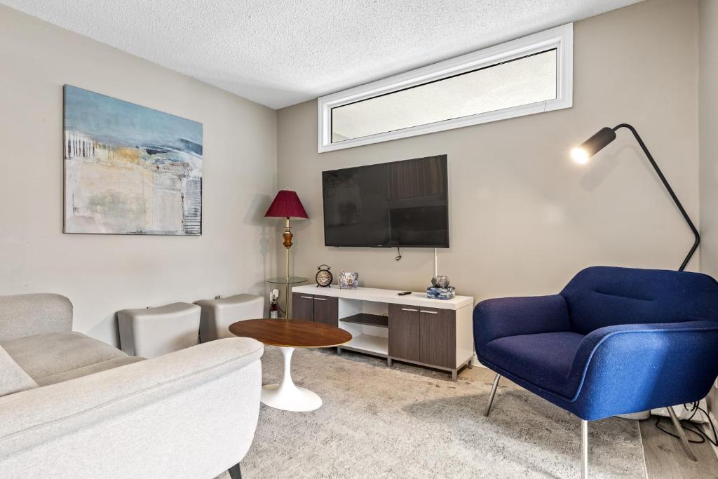 a living room with a blue chair and a tv at 14 minutes from downtown, Luxury home in Nepean in Ottawa